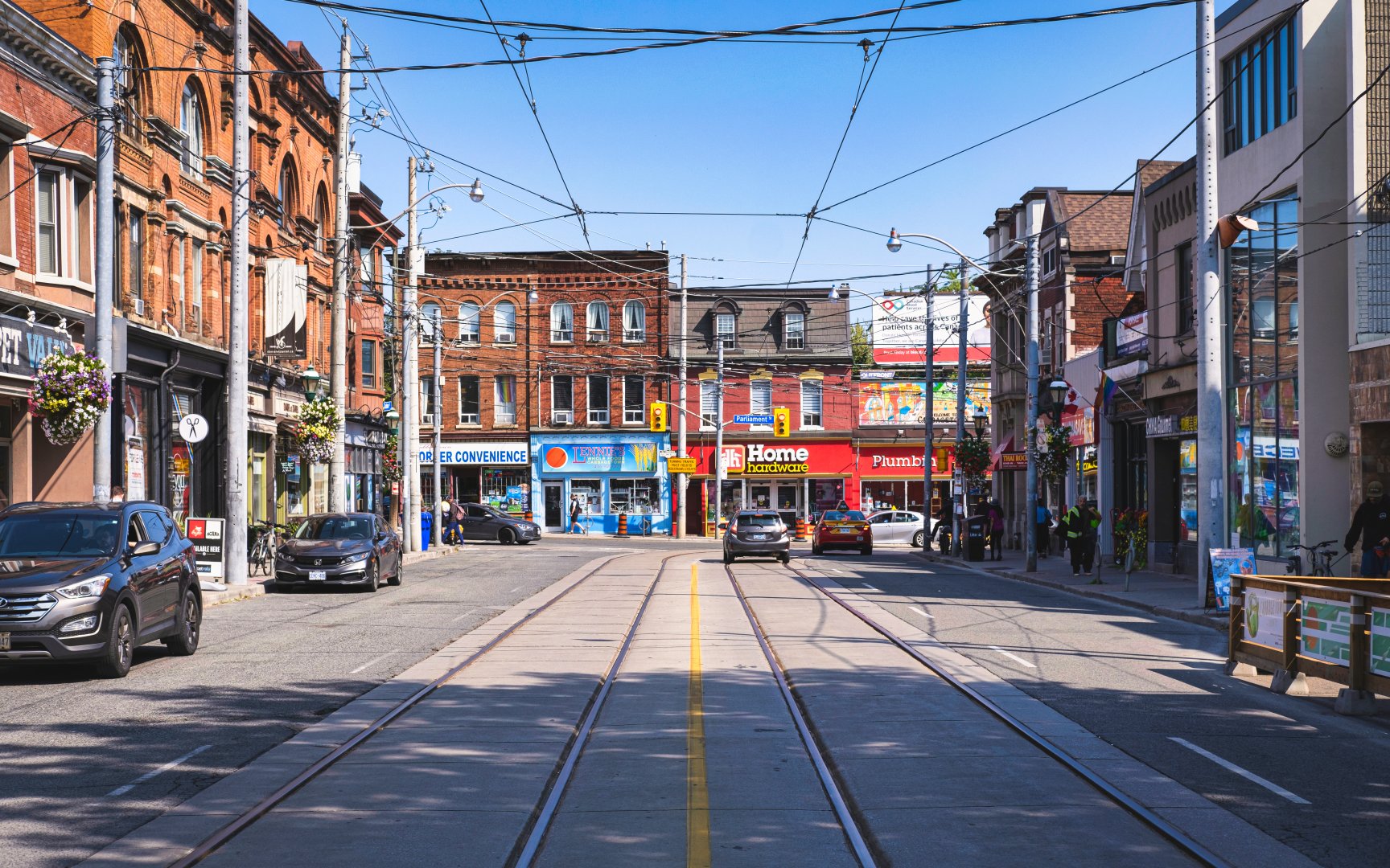 Parliament Street looking north, Cabbagetown, Toronto — streetcar tracks, red-brick buildings, and neighbourhood retail
